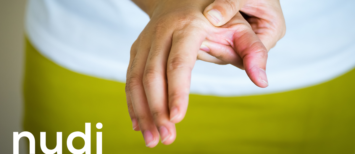 Woman rubbing her stiff, aching hands in menopause