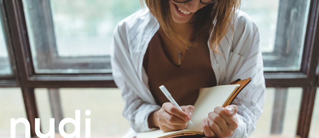 Woman writing notes to prepare for her HRT review